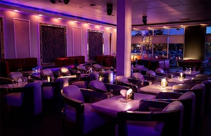 The lounge dining room in warm violet light with reserved seating.