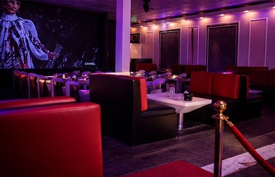 Intimate lounge booths beside the venue's LED wall.